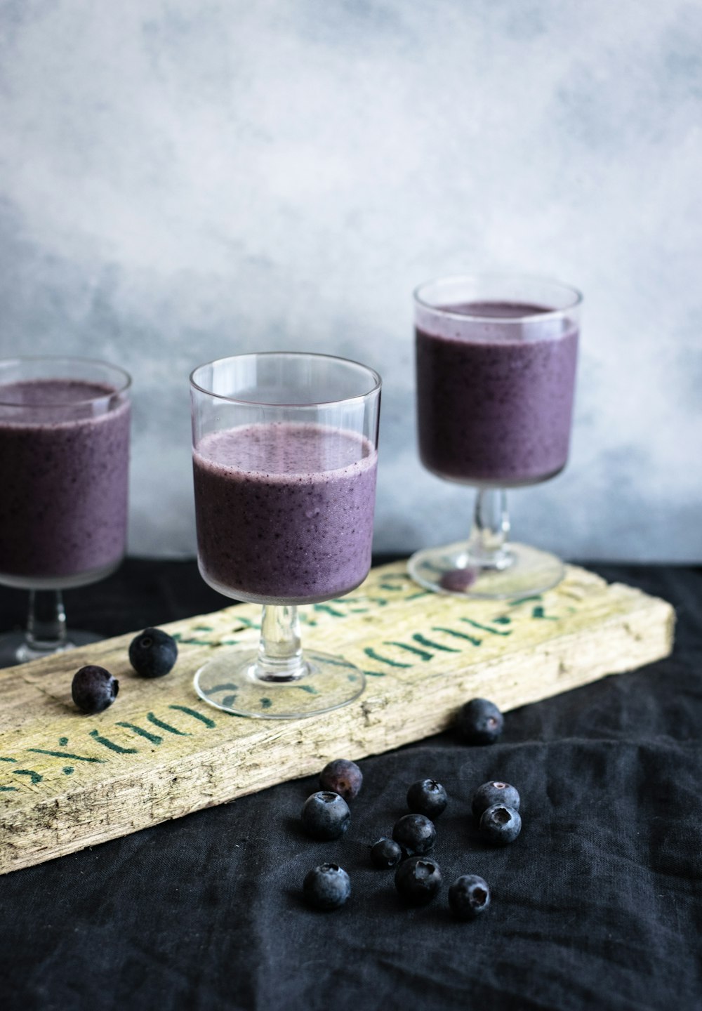 three clear drinking glasses filled with grape juices