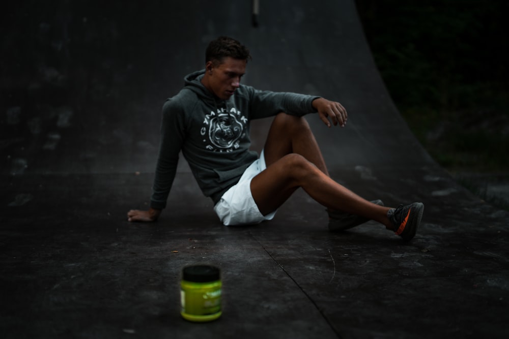 man sitting on skateboard tracks