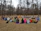 Children and adults sitting in a circle outdoors, sharing a moment of calm and connection.