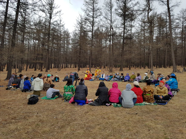 A group of diverse campers sitting in a circle on the forest floor, sharing stories and smiling.