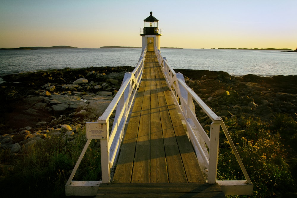 brown and white wooden dock with light house