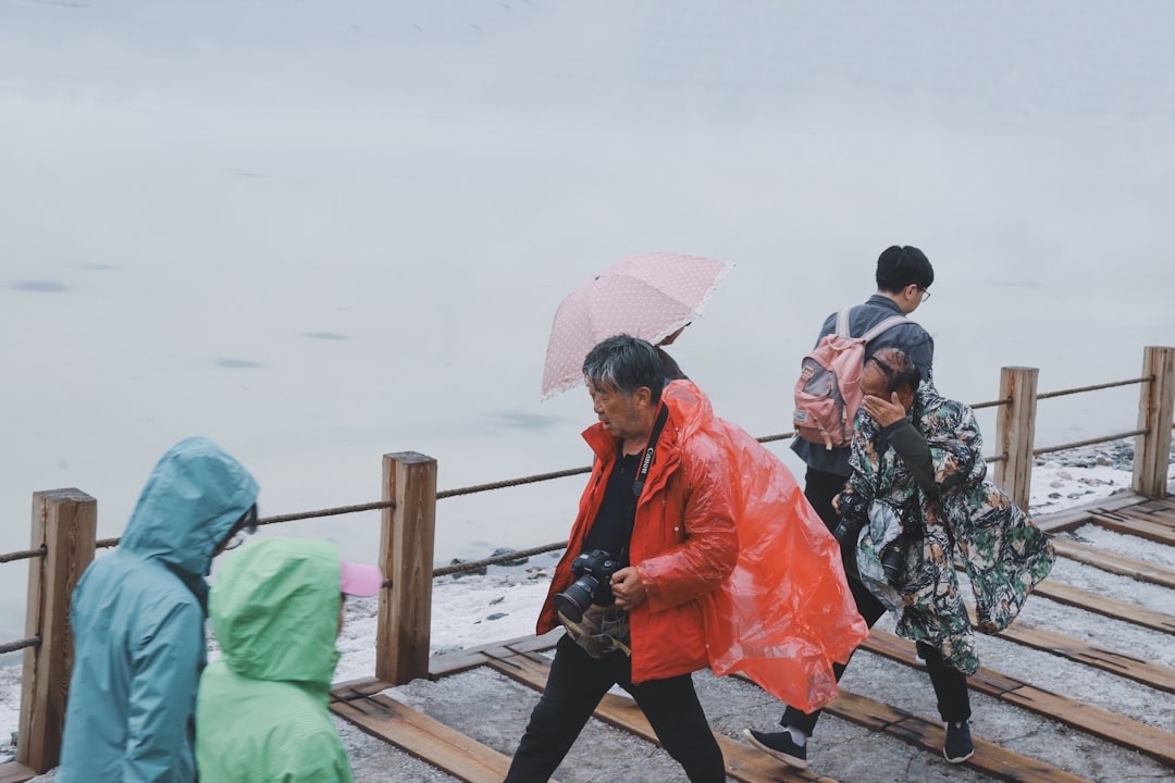 group of people walking on bridge under gray sky