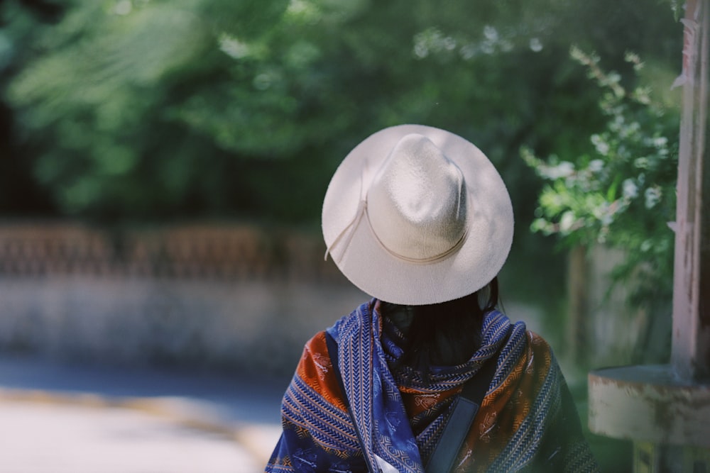 person wearing gray fedora hat near green leaf trees during daytime