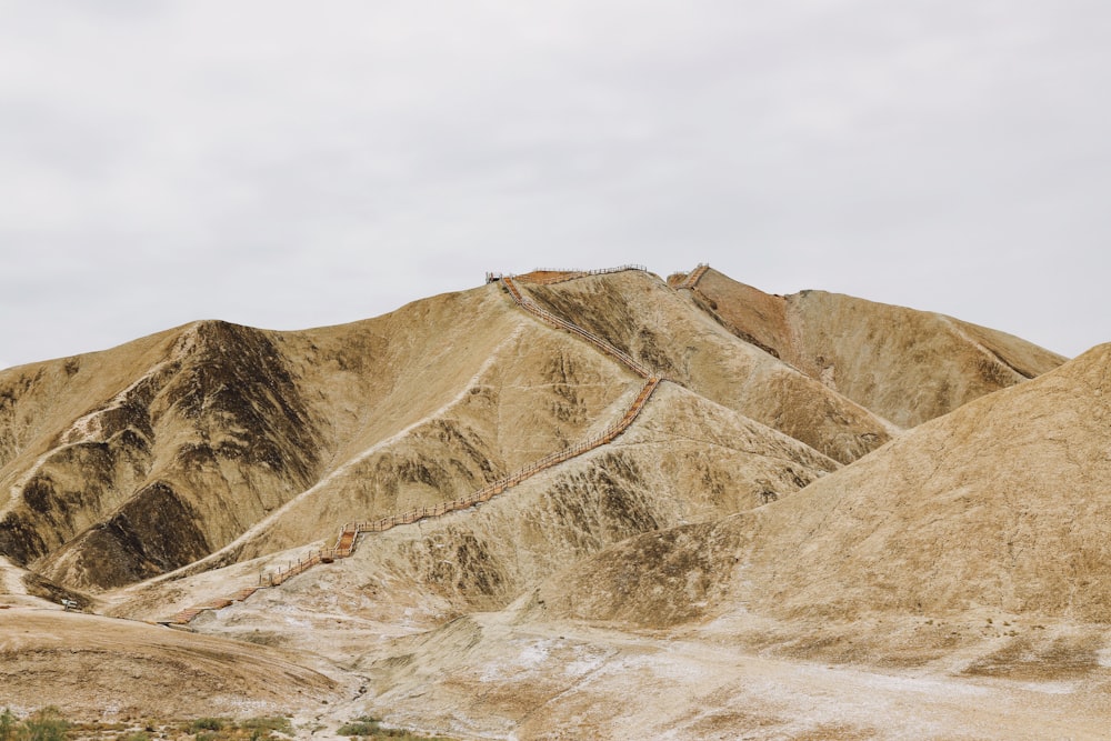 beige mountain under cloudy sky