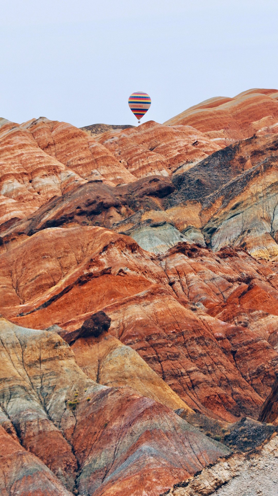 red and brown hot air balloon above mountain