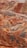 A vibrant and colorful landscape features layered hills and mountains with distinct striations of red, orange, and yellow hues. The terrain is rugged and undulating with a lone bus traveling on a narrow road that winds through the unique geologic formations.