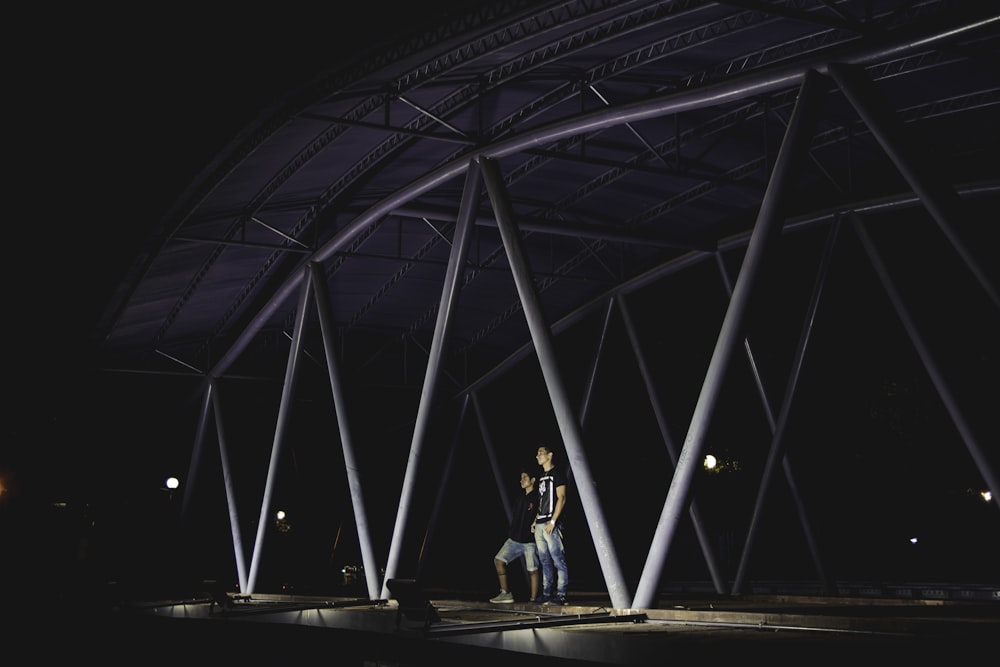 two peson standing bridge during night