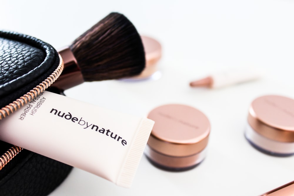 Nude by Nature soft-tube beside brown makeup brush