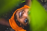 smiling girl under green leaves