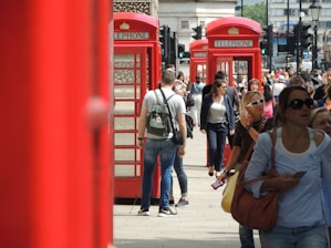 A vibrant London street scene with people using smartphones under clear skies.