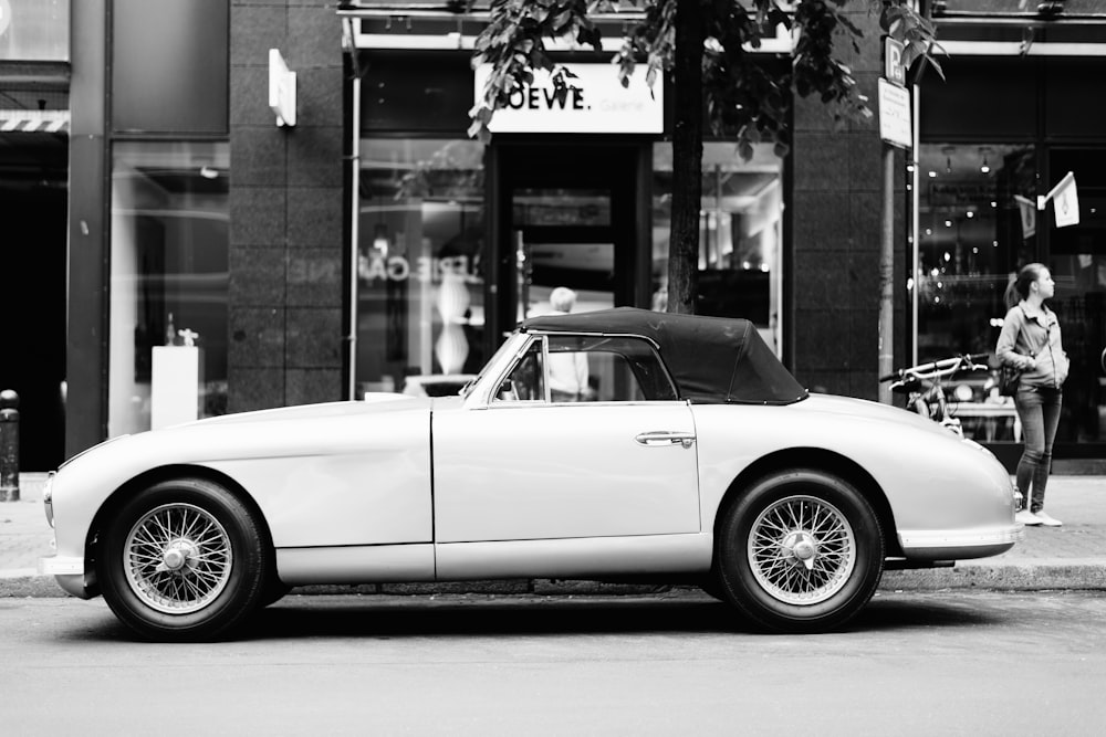 greyscale photo of classic convertible coupe on road
