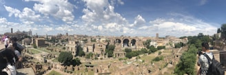 Panoramic view of ancient Syrian ruins at sunset with tourists exploring.