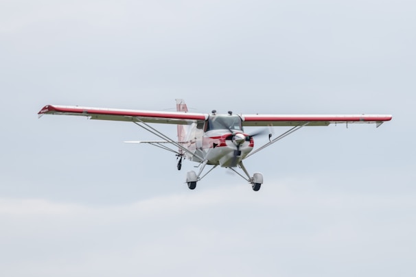 flying red and white biplane during daytime