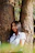 girl leaning on tree