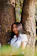 girl leaning on tree