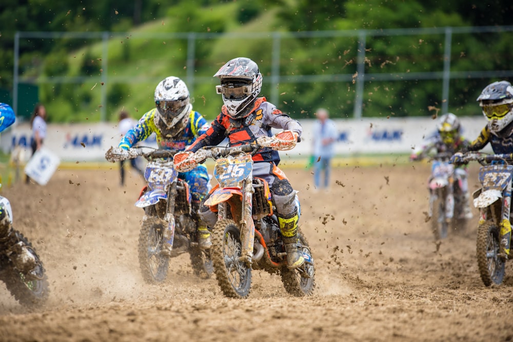 Fünf Fahrer fahren tagsüber Motocross-Dirtbike auf schlammiger Rennstrecke