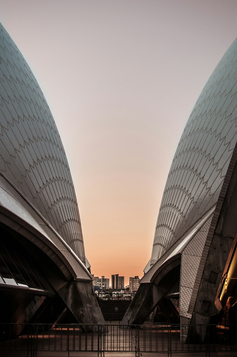 dois edifícios arquitectónicos cinzentos tomados sob o céu limpo durante o dia