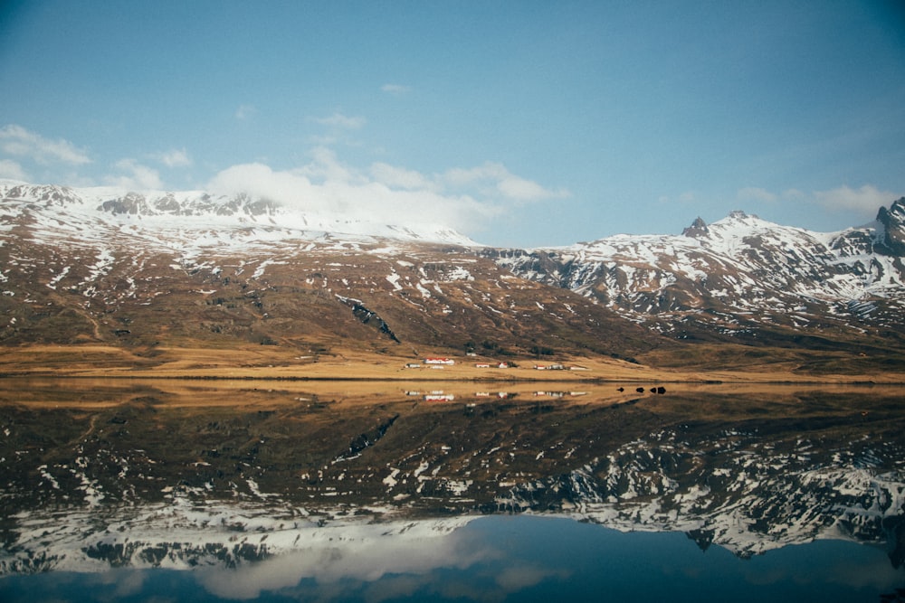 body of water surrounded by mountains under blue sky during daytime