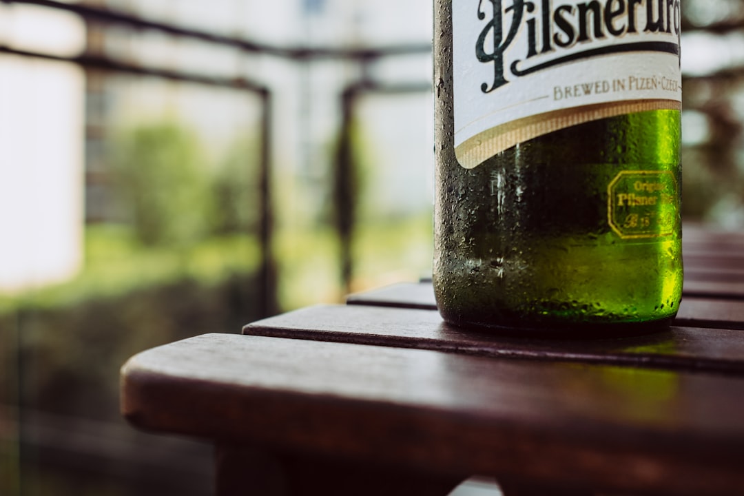 green wine bottle on brown wooden table