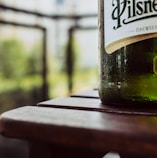 green wine bottle on brown wooden table