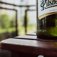 green wine bottle on brown wooden table