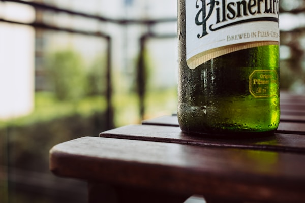 Green wine bottle on brown wooden table
