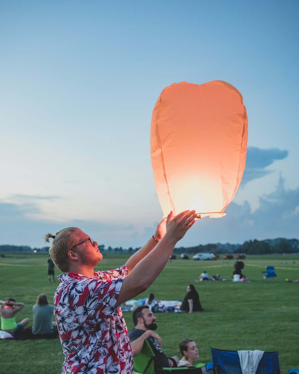 man holding flying lantern in park