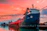 A professional cargo ship docked at a bustling international port during sunset.