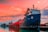 Image of a cargo ship docked at a Mozambique port during sunset.