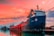 Image of a cargo ship docked at a Mozambique port during sunset.