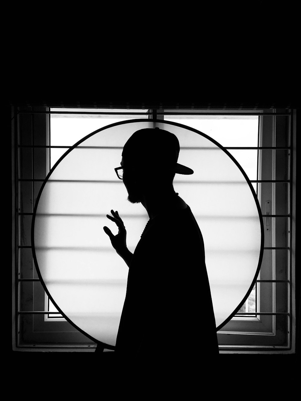 silhouette of man standing on window