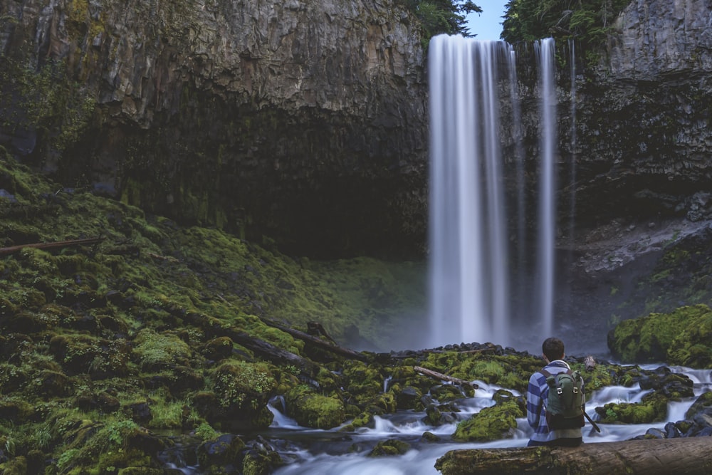 Photographie en accéléré d’une personne devant des chutes d’eau