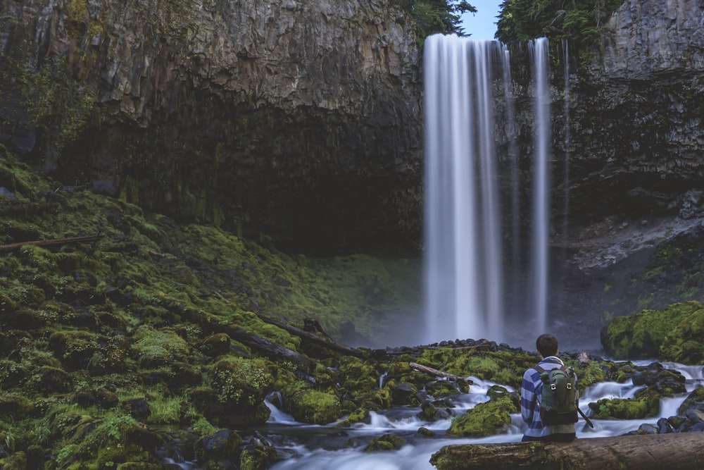 Fotografía de lapso de tiempo de una persona frente a cascadas