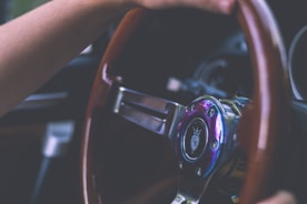Close-up of a confident driver gripping the steering wheel on a sunny day