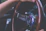 Close-up of hands on a steering wheel demonstrating adaptive driving techniques.