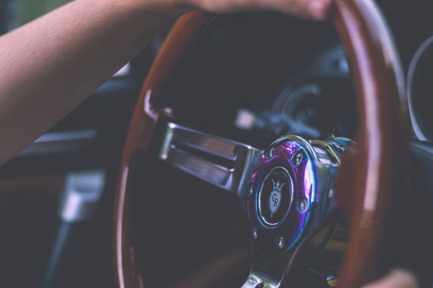 A close-up of a racing wheel with hands gripping it tightly.