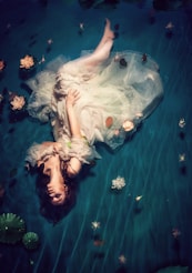 woman wearing dress and lying on teal cloth onlyfans