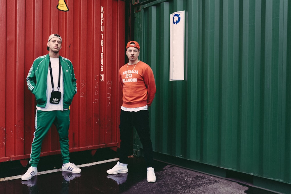 two men standing between intermodal containers