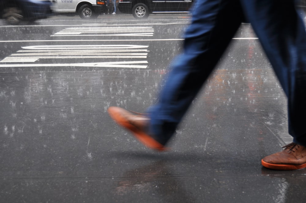 man wearing blue pants walking on street