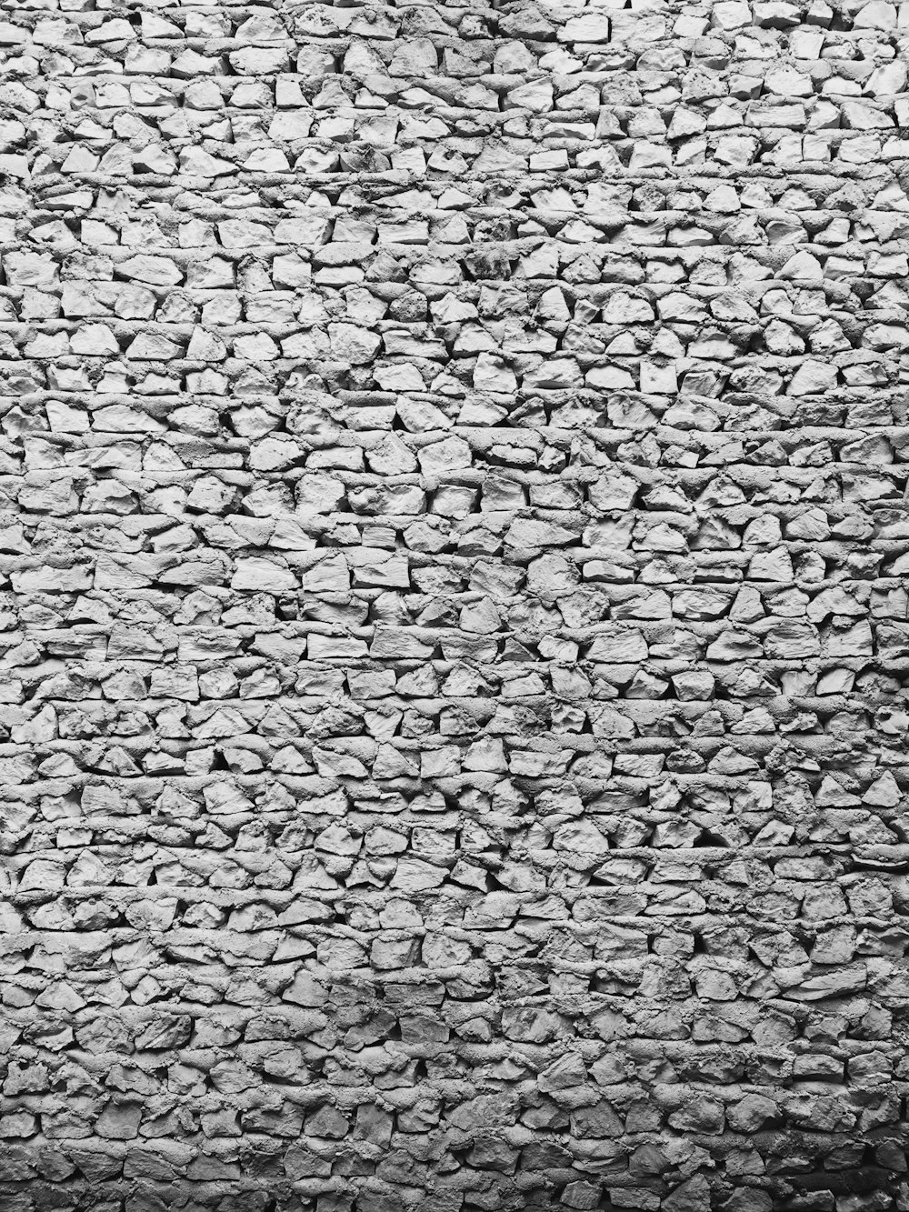a black and white photo of a stone wall