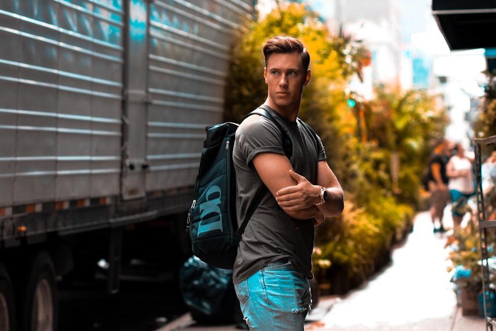 man wearing gray shirt and backpack