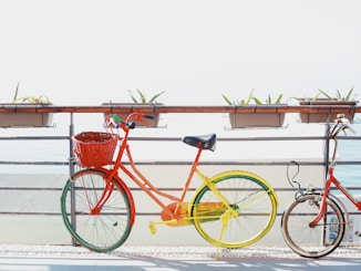 two red bicycles near railing