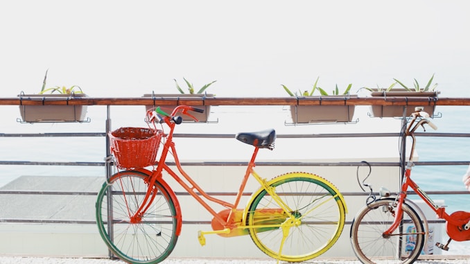 two red bicycles near railing