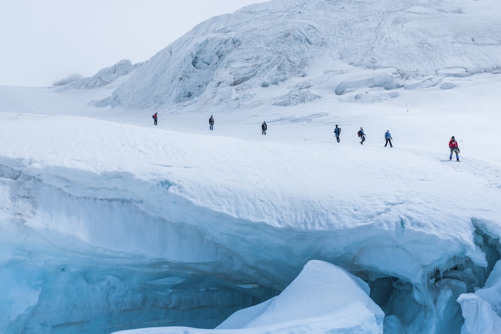 Pessoas caminhando na montanha de neve durante o dia