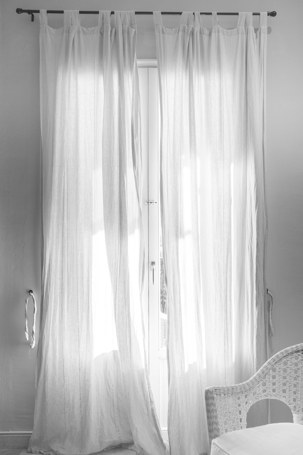 white window curtain hanging on black steel rod