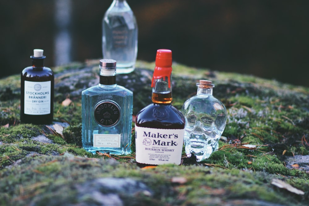 five assorted-brand bottles on top of grasses