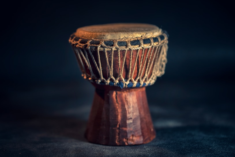 A handcrafted Viking drum with intricate Norse carvings resting on a wooden table.