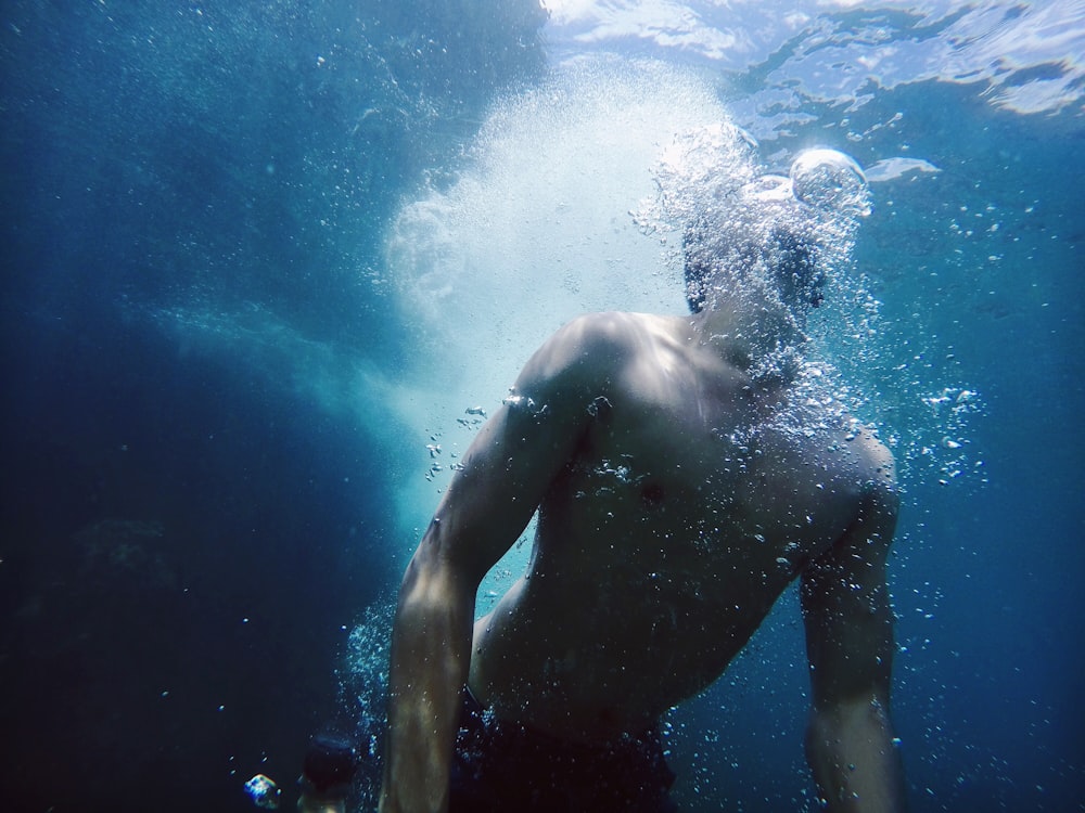 man swimming under water