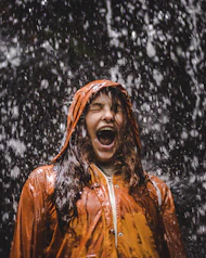 close-up photo of woman in orange coat