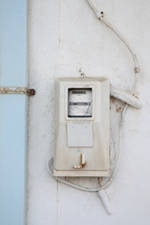 A technician inspecting a modern electrical meter on a residential home.